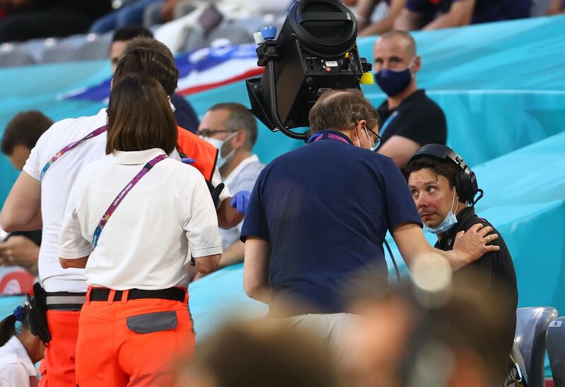 A camera man is checked on after being injured following the pitch invasion by the Greenpeace protester. Reuters