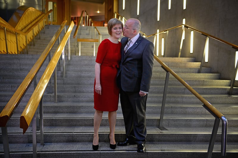 Ms Sturgeon is congratulated by her husband Peter Murrell after being formally voted in as Scotland's First Minister in 2014. Getty