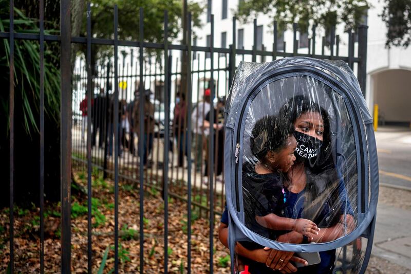 Dana Clark and her 18-month-old son Mason wait in line at City Hall as early voting begins for the upcoming presidential election in New Orleans, Louisiana, on October 16, 2020. Reuters