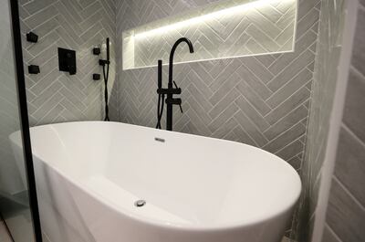 Stephanie Farah installed a standalone bath in the guest bathroom with herringbone tile design. Chris Whiteoak / The National