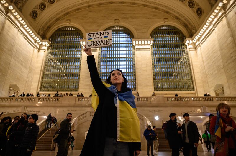 Activists hold placards during a protest in solidarity with Ukraine, at Grand Central Station in New York. AFP