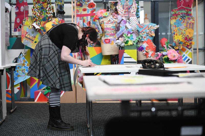 A second year student studying textiles and surface design works during a session at the University of Bolton, after students on practical courses started returning to their studies. AFP