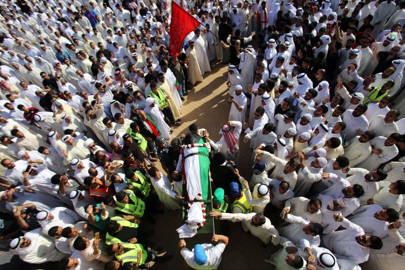Mourners carry the body of one of the victims of the Al Imam Al Sadeq mosque bombing, during a mass funeral at the Jaafari cemetery in Kuwait City on June 27, 2015. Yasser Al Zayyat/AFP Photo 

