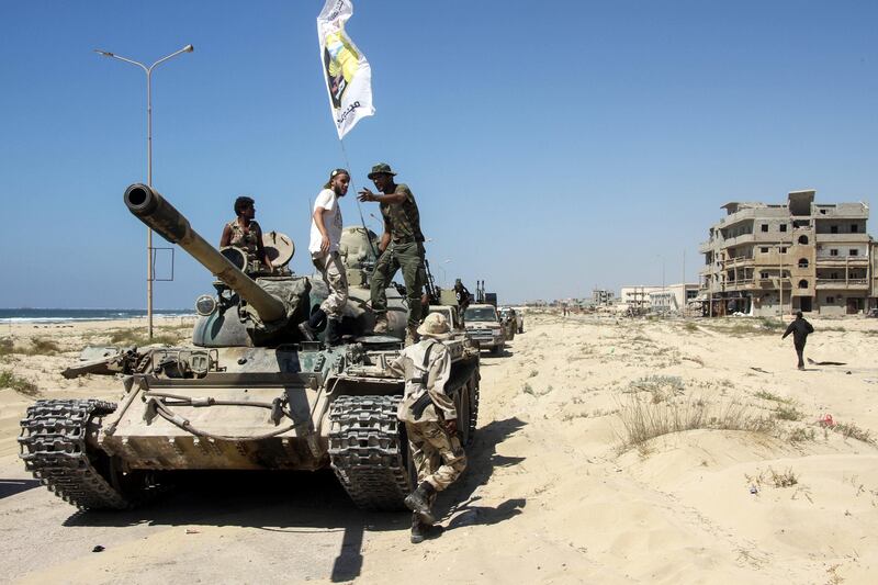 Members of the Libyan National Army, loyal to Field Marshal Khalifa Haftar, riding over a tank in the eastern city of Benghazi's central Sabri district on July 5, 2017, during a military operation to retake the last remaining neighbourhood under extremist control. AFP Photo