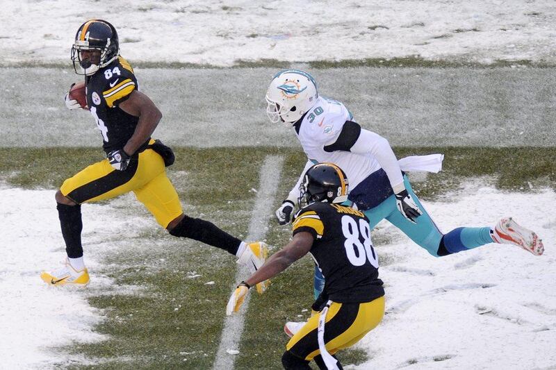 Steelers wide receiver Antonio Brown runs with the ball in Pittsburgh on Sunday. Tom E Puskar / AP