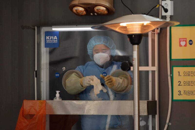 A medical worker prepares to take a sample at coronavirus testing site in Seoul, South Korea. AP Photo