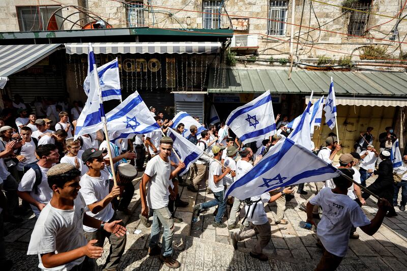 Israelis carry national flags as they walk in Jerusalem's Old City. Reuters