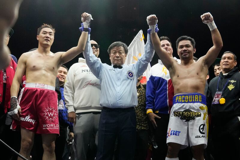 Manny Pacquiao and DK Yoo raise their arms after their exhibition match at the KINTEX. AP