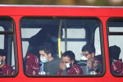 Exhausted migrants rescued from the English Channel by the UK Border Force sit on a bus after arriving in the early hours at Dover harbour. Reuters