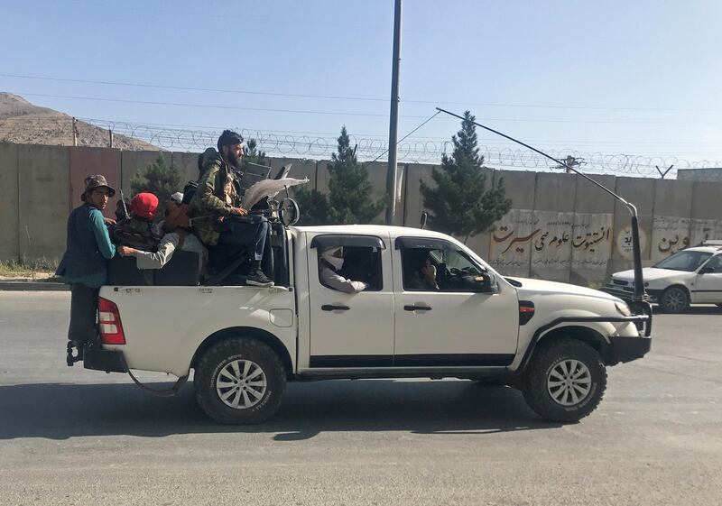 Taliban fighters ride on a truck through Kabul on Sunday.