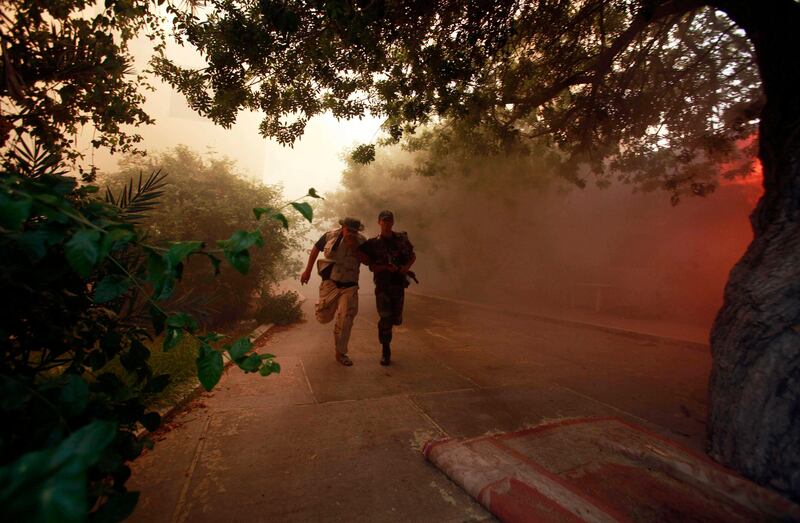 Anti-Gaddafi fighters run toward a burning house believed to belong to a Gaddafi loyalist in Tripoli September 20, 2011. Citizens in the neighborhood burnt several houses belonging to senior military officers they called Gaddafi loyalists. REUTERS/Suhaib Salem (LIBYA - Tags: CONFLICT) *** Local Caption ***  SJS13_LIBYA-_0920_11.JPG