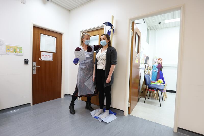 A woman is screened before receiving a Moderna booster vaccine in a clinical study at St George's University of London. PA