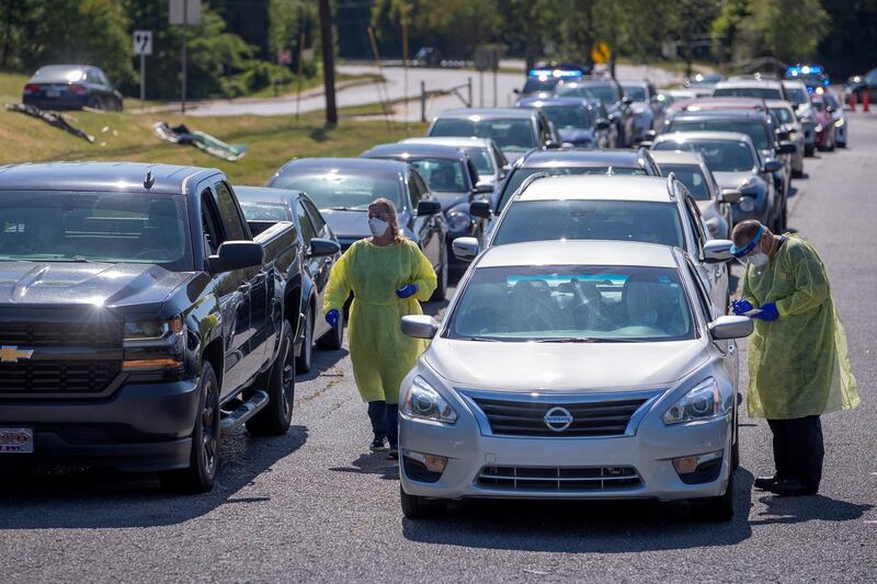 Drivers and passengers are screened by healthcare workers from the DeKalb County Board of Health at a free swabbing site at The House of Hope Atlanta church in Decatur, Georgia, US.   EPA