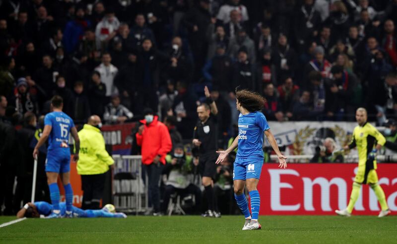 Marseille's Matteo Guendouzi reacts after Dimitri Payet goes down after being hit by a water bottle thrown by a fan. Reuters
