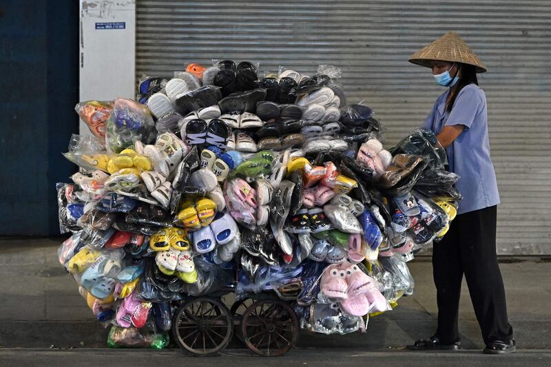 A street vendor pushes a cart of shoes and slippers in Hanoi. AFP