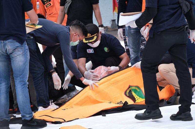 Indonesian investigators examine body bags with human remains and debris from Sriwijaya Air flight SJ182 to be examined by investigators in Jakarta, Indonesia.  Getty Images