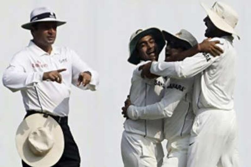 The Indian cricketers Virender Sehwag, second right, and Harbhajan Singh, right, congratulate Amit Mishra, second left, for dismissing the Australian captain Ricky Ponting.