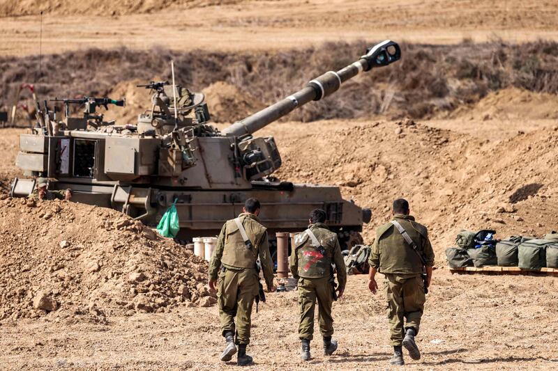 Israeli soldiers near a self-propelled howitzer near the border with Gaza in southern Israel. AFP