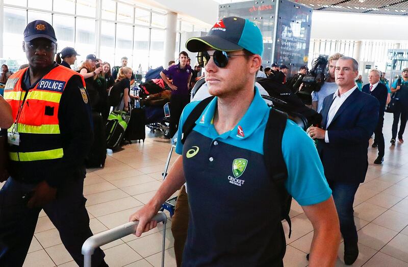 epa06631768 Australian cricket captain Steve Smith (C) departs from Cape Town International airport, South Africa, 27 March 2018. Australia skipper Steve Smith has been suspended by the International Cricket Council (ICC) for his part in a ball tampering scandal during the third test against South Africa. Smith admitted some senior players were aware of the ball tampering attempt. Smith and David Warner stepped down as captain and vice-captain of the Australian team in consequence to the ball meddling scandal.  EPA/NIC BOTHMA