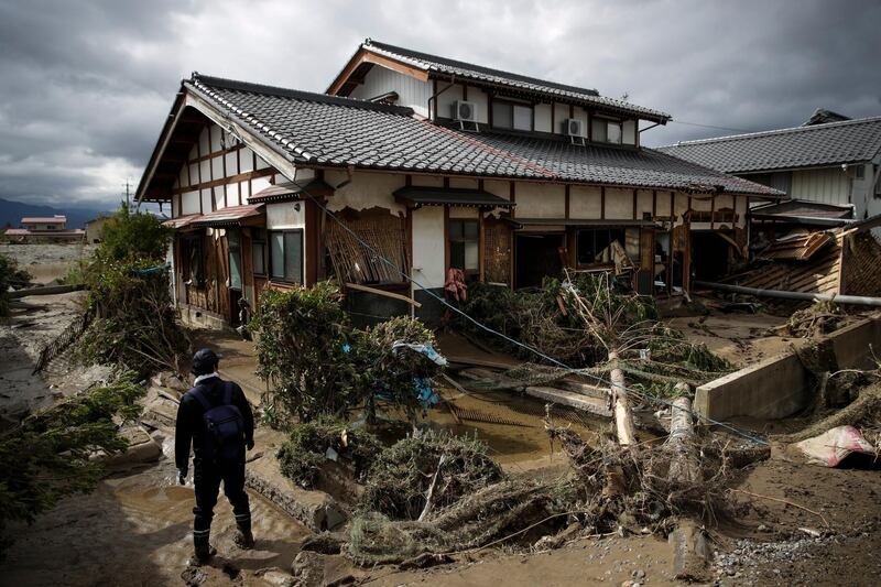 A man surveys a home damaged by Typhoon Hagibis in Nagano, Japan. More victims and more damage have been found in typhoon-hit areas of central and northern Japan, where rescue crews are searching for people still missing. AP Photo