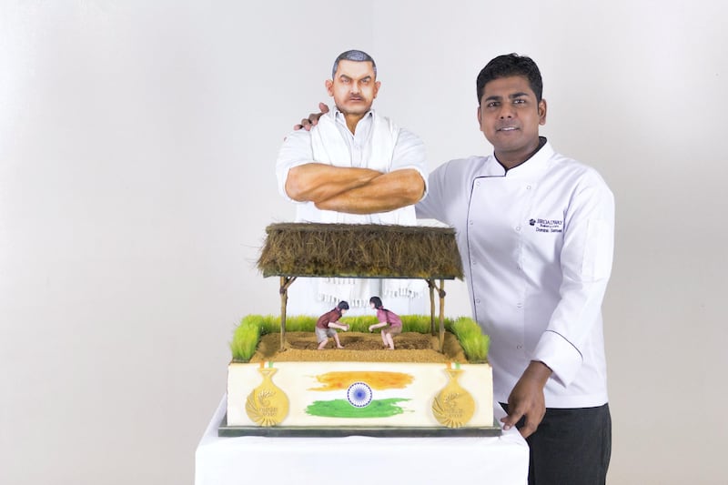 DUBAI, UNITED ARAB EMIRATES - AUG 13: 

Head chef, Dominic Joseph Samuel, stands next to a replica of a DHS150,000 gold coated cake,  in Broadway Bakery offices.

The Dubai bakery has created the cake as a tribute to the 70th anniversary of India’s Independence falling on August 15 based on the theme of one of the most successful Bollywood movies, called ‘Dangal’.

Cake artists at Broadway Bakery crafted the structure featuring Bollywood superstar Aamir Khan who plays the role of Mahavir Singh Phogat, a wrestler, in the movie, who is determined to empower his daughters to become Olympic medal-winning wrestlers.

(Photo by Reem Mohammed/The National)
