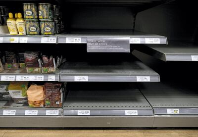 (FILES) In this file photo taken on March 31, 2020 Empty shelves where packets of flour would normally be stocked are pictured below half-empty egg, and sugar stocks, inside a Waitrose supermarket store in north London, as life in Britain continues during the nationwide lockdown to combat the novel coronavirus pandemic. - "Flour is one of those invisible bits of the food chain until it isn't there," said Alex Waugh, director general at Nabim, which represents Britain's millers producing the staple. Along with pasta, rice and tinned food, flour is hard to come by in UK supermarkets since shoppers began stockpiling in large quantities around a month ago, even before the country went into lockdown. (Photo by Isabel INFANTES / AFP)