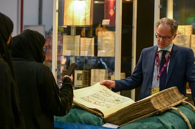 Christoph Auvermann from Librairie Clavreuil displays a 15th-century book of hymns he hopes to sell at the Abu Dhabi International Book Fair. Khushnum Bhandari / The National
