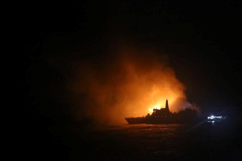 A ship is silhouetted by the glow from the fire on board that continued to burn overnight.  Reuters