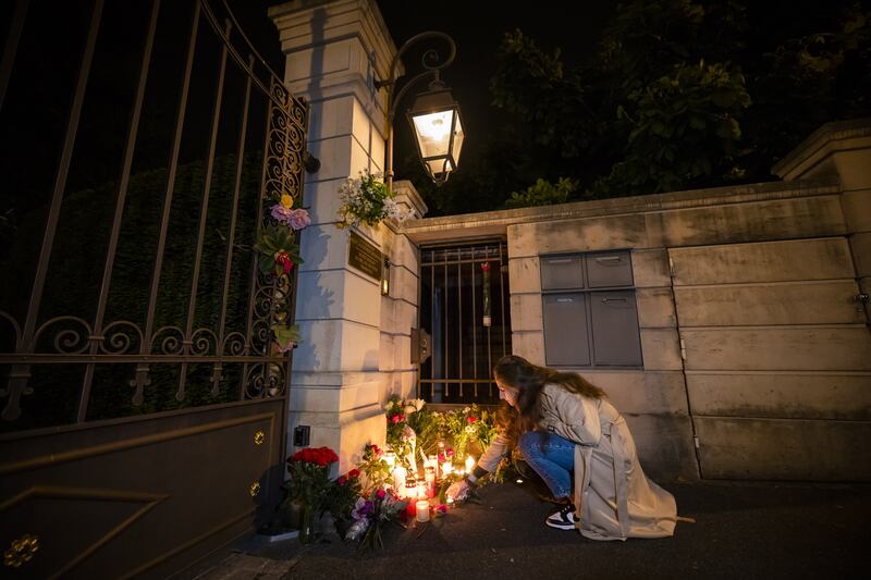 A woman lights candles at the gate of the house of singer Tina Turner in Kuesnacht, Switzerland, following news of her death. EPA