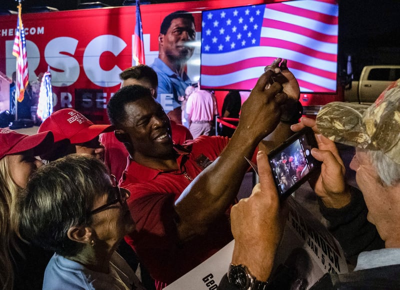 Republican candidate for US Senate Herschel Walker takes a picture with supporters in Kennesaw, Georgia during a "Unite Georgia Bus Stop" campaign rally on the eve of the midterm elections. AFP