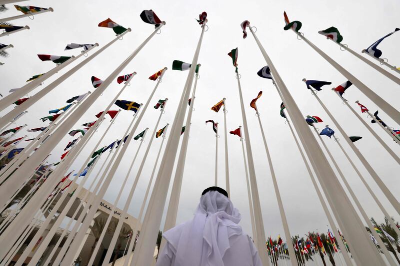 An Emirati visitor stands beneath the waving flags of countries participating in the Expo 2020. Gulf countries experienced a solid expansion in non-oil sectors in the first quarter of 2022. AFP