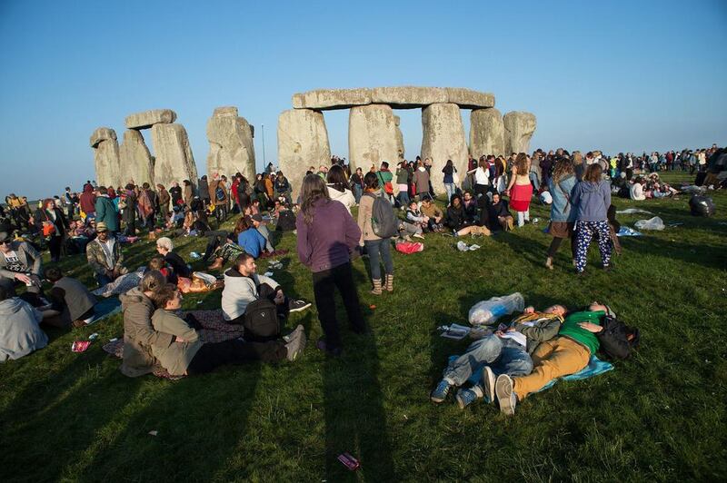 People gather at Stonehenge for the summer solstice dawn ceremony. The ancient monument may lose its World Heritage status owing to a proposed tunnel nearby. Getty Images