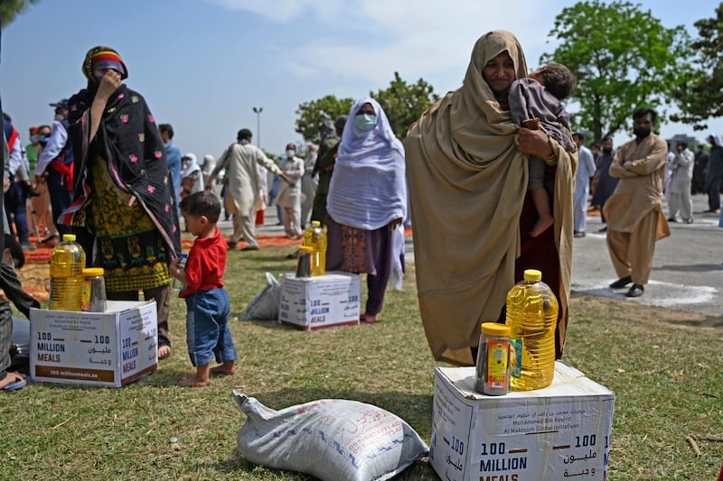 Women prepare to take home provisions distributed by the UAE embassy in Islamabad.