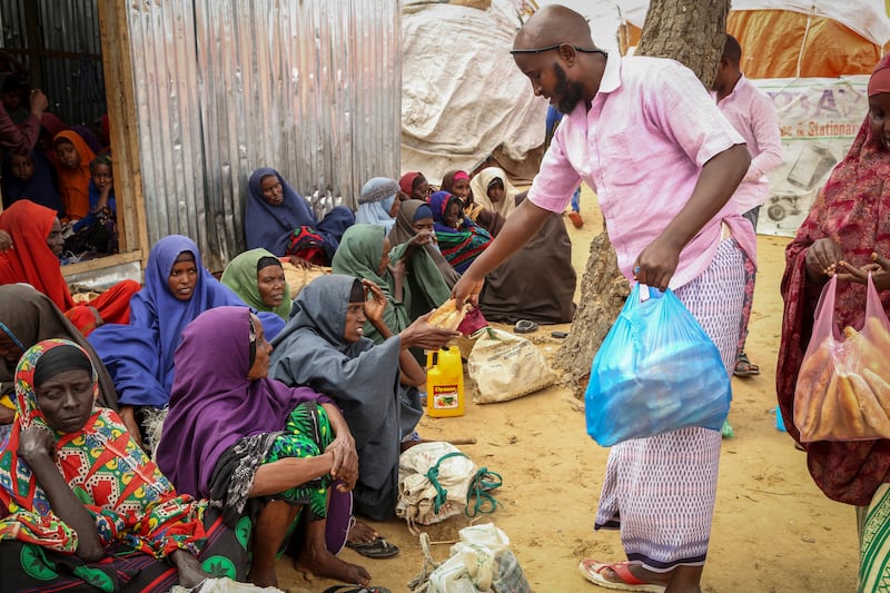 Somalis who fled drought-stricken areas receive food donations from city residents at a makeshift camp on the outskirts of Mogadishu. AP