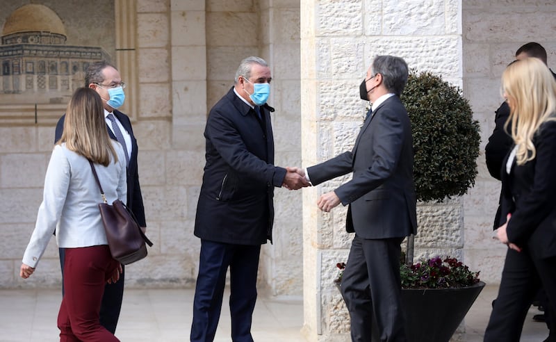 Hussein Al Sheikh, a member of the Palestinian PLO Executive Committee, centre left, shakes hands with Mr Blinken. EPA