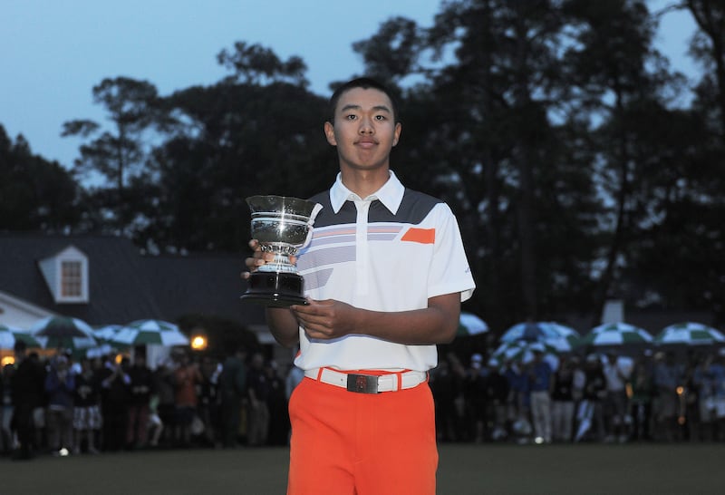 Tianlang Guan of China poses with the trophy for the low amateur during the fourth round of the 77th Masters golf tournament at Augusta National Golf Club on April 14, 2013 in Augusta, Georgia. Adam Scott of Australia sank a 10-foot birdie putt on the second playoff hole Sunday to beat Angel Cabrera and win the 77th Masters, becoming the first Australian golfer to capture the green jacket. AFP PHOTO/Jewel Samad
 *** Local Caption ***  912163-01-08.jpg