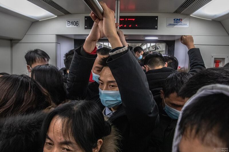 Passengers wearing protective face masks ride a crowded subway on New Year's Eve in Wuhan, China. EPA