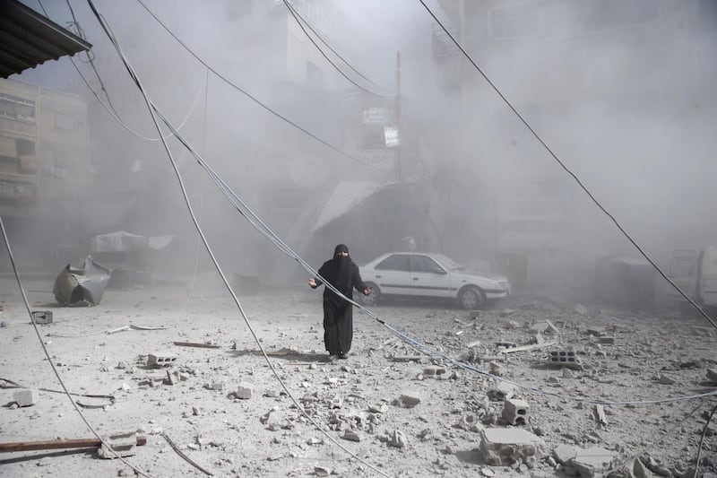 A woman gestures as she walks on rubble of damaged buildings after an airstrike in the besieged in eastern Ghouta. Reuters