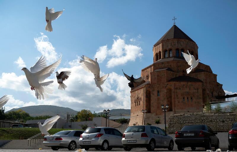 Pigeons fly near Holy Mother of God Cathedral in Stepanakert during a military conflict in the separatist region of Nagorno-Karabakh. Armenia and Azerbaijan say they have agreed to a ceasefire in Nagorno-Karbakh starting at noon Saturday. AP