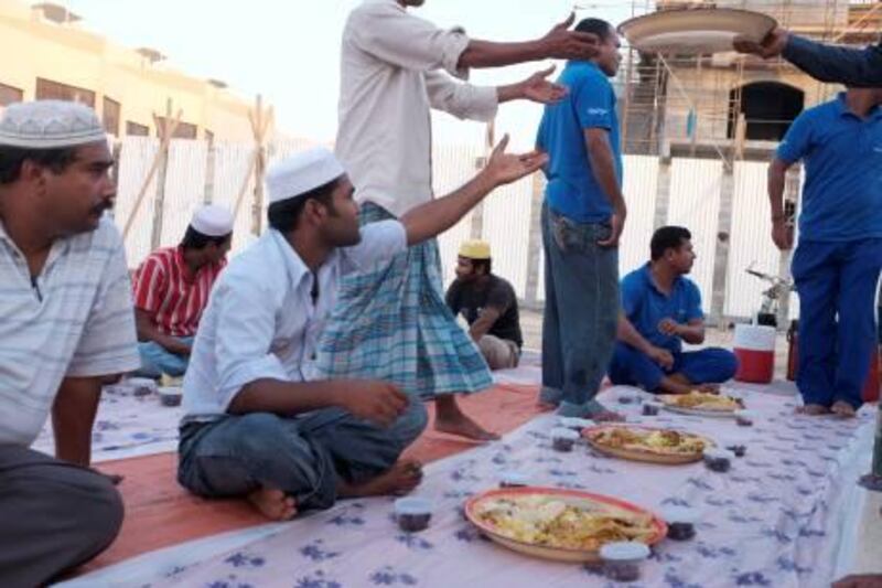 August 01.  Volunteers and worshippers devide a Zakat (charity) meal in preperation for Iftar at a portacabin mosque located between construction sites in Khalifa City A.  August 01, Abu Dhabi. United Arab Emirates (Photo: Antonie Robertson/The National)
