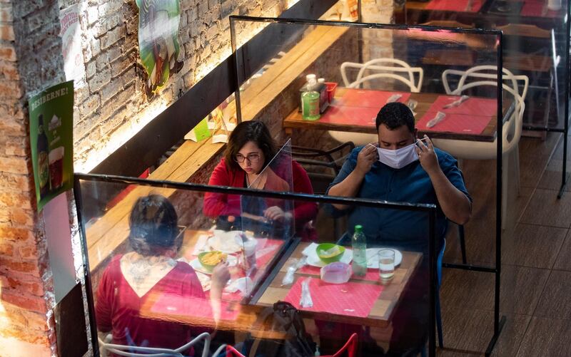 People eat lunch at a restaurant with plastic dividers between tables, as a preventative measure amid the Covid-19 pandemic in Sao Paulo, Brazil. AP Photo
