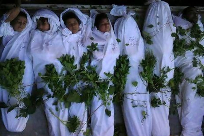 The shrouded bodies of Syrians, including children, during a funeral in Daraya, near Damascus.