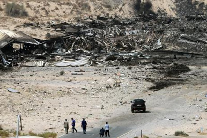 epa02315969 United Arab Emirates (UAE) officials are seen at the site where a cargo airplane crashed while taking off from Dubai airport, United Arab Emirates, on 04 September 2010. A United Parcel Services (UPS) cargo plane crashed near Dubai airport on 03 September 2010 as it was taking off for Germany. Officials in the Emirate said two people died in the incident.  EPA/ALI HAIDER