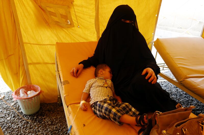 epa06104030 A Yemeni woman sits near her cholera-infected child receiving treatment amid an acute cholera outbreak, inside a makeshift tent at a hospital in Sana’a, Yemen, 22 July 2017. According to the World Health Organization, an acute cholera outbreak in conflict-affected Yemen has claimed the lives of at least 368,207 suspected cases and 1,828 deaths in just three months since the outbreak started, confirming children under 15 years of age represent 41 percent of all suspected cases.  EPA/YAHYA ARHAB