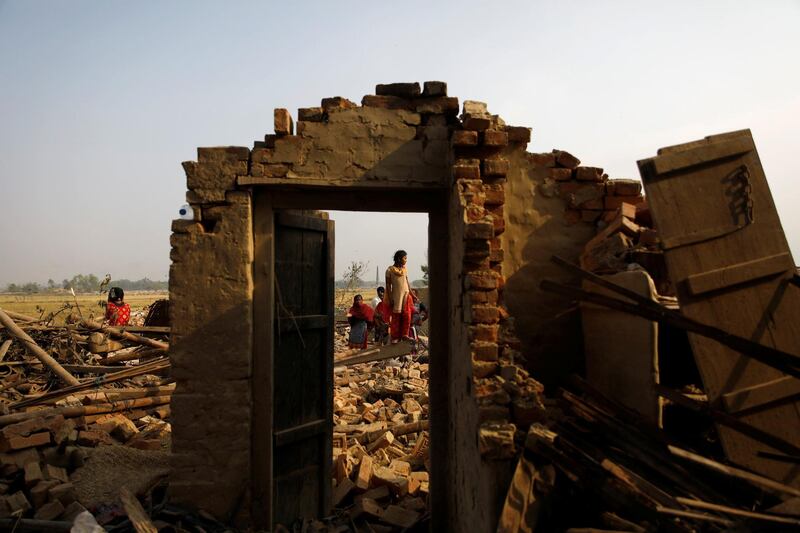 Villagers stand on the debris of the houses after it was hit by a storm in Bara district, Nepal. Reuters