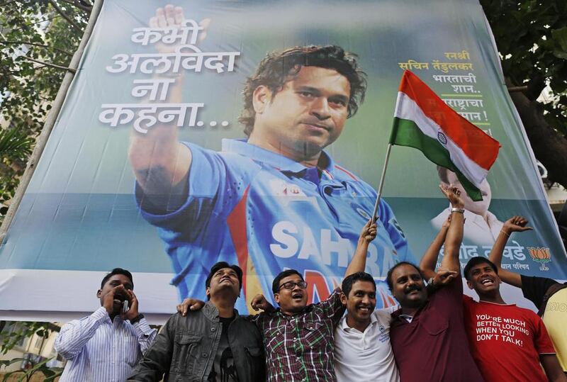 Fans stand in front of a billboard honouring Tendulkar. The billboard reads, "Never say goodbye". Danish Siddiqui / Reuters