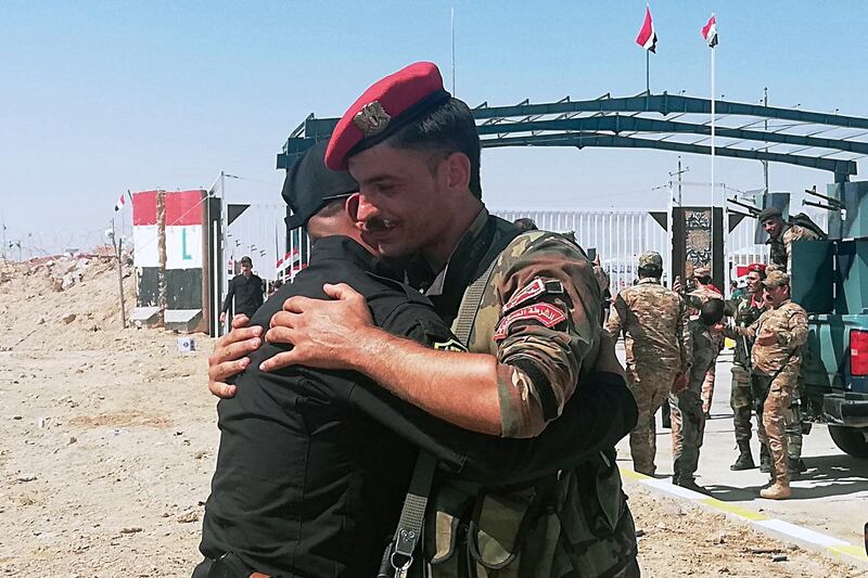 Iraq and Syria border guards soldiers congratulate each other during the opening ceremony of the crossing between the Iraqi town of Qaim and Syria's Boukamal in Anbar province, Iraq. AP Photo