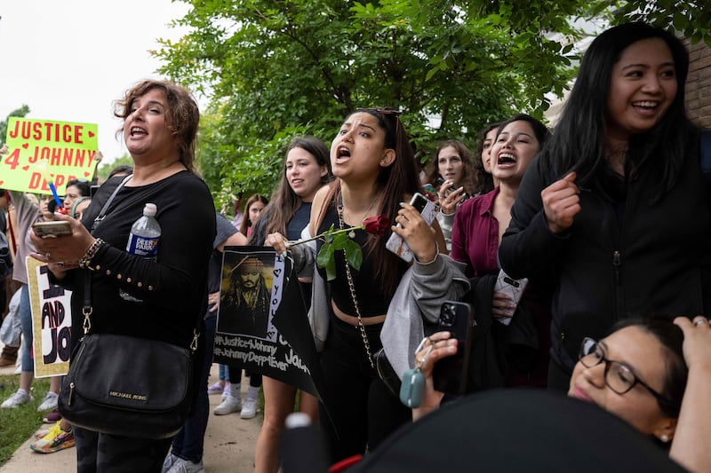 Depp fans yell at a supporter of Heard outside the courthouse. AFP