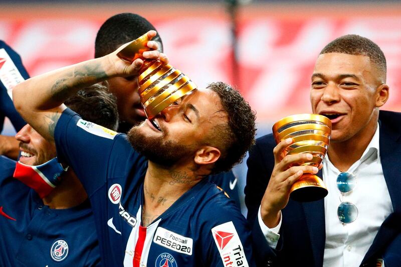 Paris Saint-Germain's French forward Kylian Mbappe (R) and Paris Saint-Germain's Brazilian forward Neymar joke with their trophies as they celebrate their victory at the end of the French League Cup final football match between Paris Saint-Germain vs Olympique Lyonnais at the Stade de France in Saint-Denis on July 31, 2020.  / AFP / GEOFFROY VAN DER HASSELT

