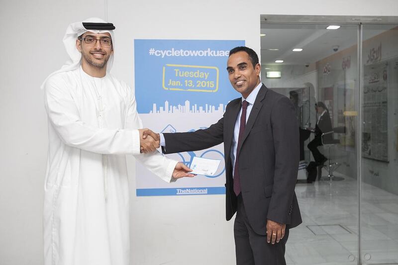 Mohammed Al Otaiba, Editor-in-Chief of The National, with Liju Mathew, a winner in the Cycle to Work contest. Mona Al Marzooqi / The National